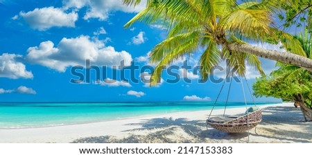 Tropical beach panorama as summer relax landscape with beach swing or hammock hang on palm tree over white sand sea beach banner. Amazing beach vacation summer holiday concept. Luxury romantic travel
