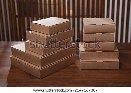 Stacked packaging boxes on wooden table indoors. Production line