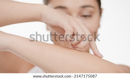 Close-up shot of young Caucasian plus size woman who touches her smooth forearm against white background | Smooth skin and beauty care concept Royalty-Free Stock Photo #2147175087