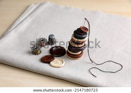 Set of sewing supplies and accessories with fabric on wooden table
