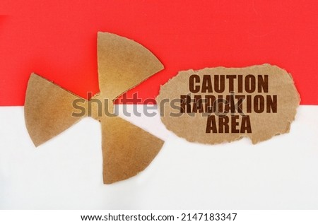 The concept of industry and radiation. On the flag of Indonesia, the symbol of radioactivity and torn cardboard with the inscription - caution radiation area