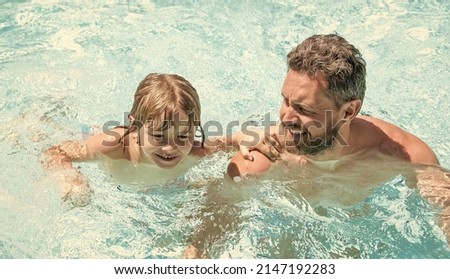 happy family of father and small boy having fun in summer swimming pool, resort