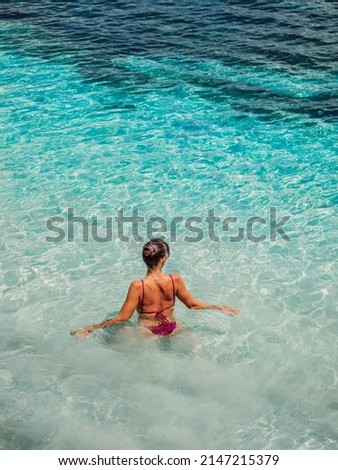Attractive young woman, bikini girl swim in tropical ocean