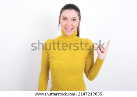 young caucasian girl in yellow turtleneck over white background showing up number six Liu with fingers gesture in sign Chinese language