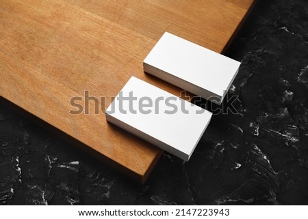 Blank white business cards on wooden board background. Mockup for branding identity. Template for graphic designers portfolios.