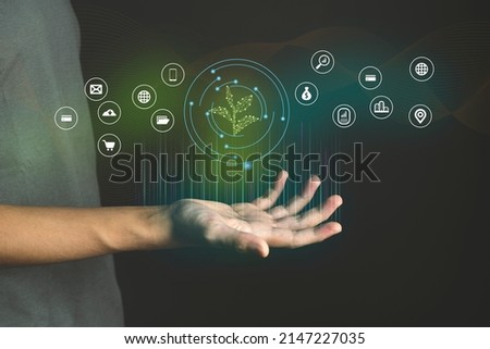 Eco Technology Hand  with glowing low poly green sprout on dark blue background Royalty-Free Stock Photo #2147227035