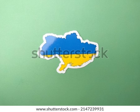 Ukraine flag stickers on a green background.