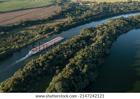 grain transport barge going up the tiete river - tiete-parana waterway Royalty-Free Stock Photo #2147242121