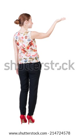 Back view of Beautiful business woman in suite looking at wall and Holds  hand up.  young brunette girl standing. Rear view people. Isolated over white background. 