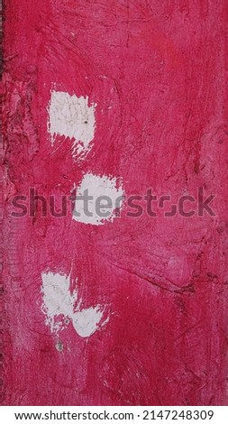 Old pink concrete wall with 3 white brush swatches of paint. Copy space