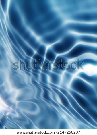 The​ abstract​ of​ surface​ blue​ water​ use​ for​ graphic​ design.The​ pattern​ of​ surface​ blue​ water​ in​ swimming​ pool​ reflected​ with sunlight​ for background.Water​ splashed​ for​background.
