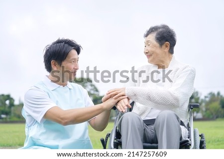 Asian senior woman on the wheelchair and caregiver outdoor