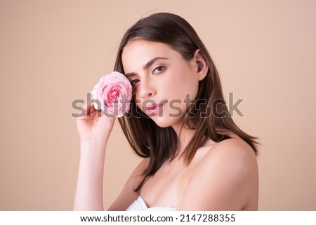Beautiful woman with natural makeup and rose flowers. Inspiration of spring and summer. Perfume cosmetics concept. Close-up portrait of a beautiful young girl with a pink rose near face. Royalty-Free Stock Photo #2147288355