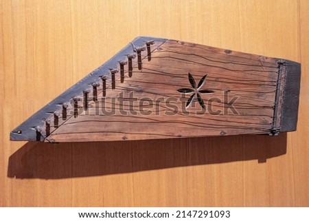 Wooden Gusli on wood background. Ancient East Slavic stringed plucked musical instrument. Top view, close-up. Royalty-Free Stock Photo #2147291093