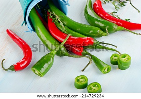 Red and green Chili Peppers on wooden background. Selective focus