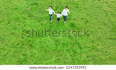 Little girl and parents running on the field. Family. Environment. Ecology. Sustainable development goals. SDGs. Royalty-Free Stock Photo #2147292991