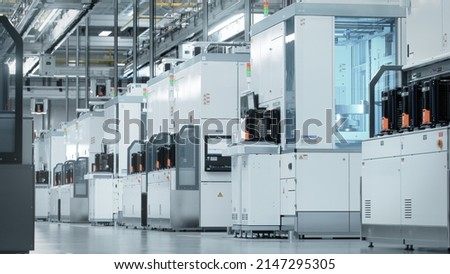 Wide shot of Bright Advanced Semiconductor Production Fab Cleanroom with Working Overhead Wafer Transfer System  Royalty-Free Stock Photo #2147295305