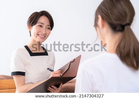 Asian women receiving courteous counseling Royalty-Free Stock Photo #2147304327