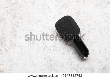 Modern microphone on light background