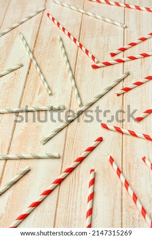 Stylish straws for drinks on light wooden background
