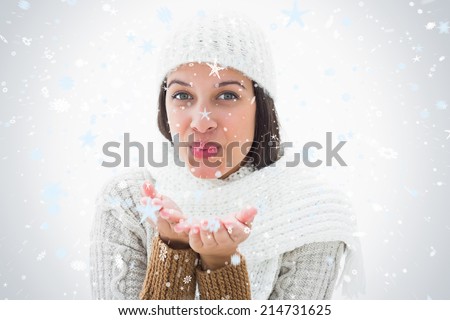 Pretty brunette blowing kiss to camera against snow falling