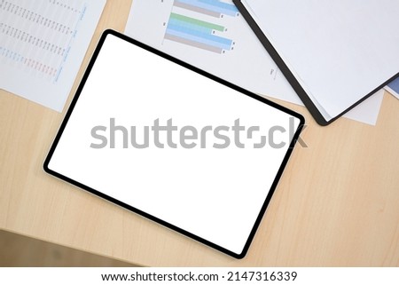 Top view, Digital tablet touchpad white screen mockup for display your graphic image is on the office desk.
