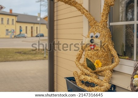 Straw bunny by the window as decor for Easter.