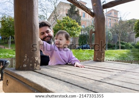 father playing with his happy and smiling little baby in the park outdoors on a sunny day Royalty-Free Stock Photo #2147331355