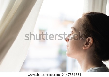 woman waking up looking out the window Royalty-Free Stock Photo #2147331361