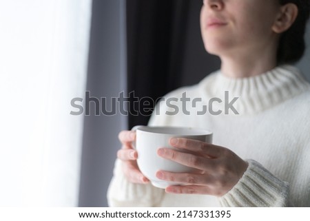 close up of woman's hands holding a big white cup of tea or coffee Royalty-Free Stock Photo #2147331395