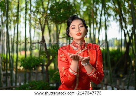 Portrait beautiful Asian woman in a Chinese cheongsam spreads her palm as blank space to insert picture for advertisement, copy space