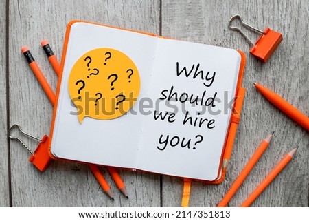 WHY SHOULD WE HIRE YOU ? text on orange notepad page