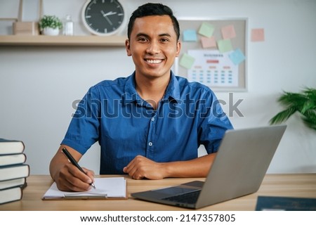A man working in office with papers and laptop on desk Royalty-Free Stock Photo #2147357805