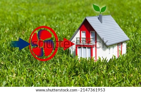 Miniature house in the grass with air heating pump or air heat pump Royalty-Free Stock Photo #2147361953