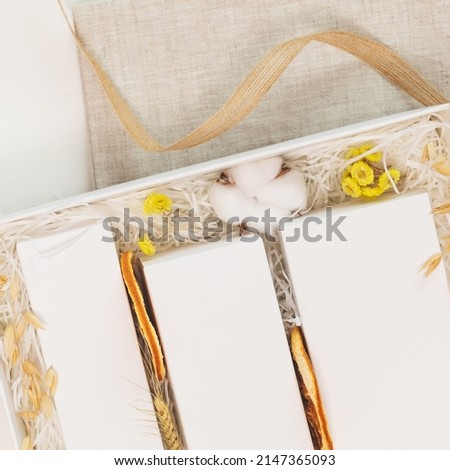 Mock up of natural beauty products. Eco friendly card with white boxes with cosmetic products in a white gift box with dry flowers on a white background. Soft image style. Empty Template Mockup Set 
