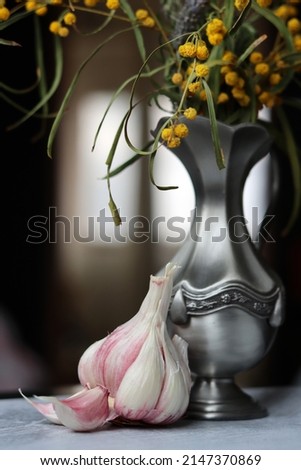 Still life with wild spring flowers in a vase. Beautiful yellow blossom of acacia. Grey textured background. 