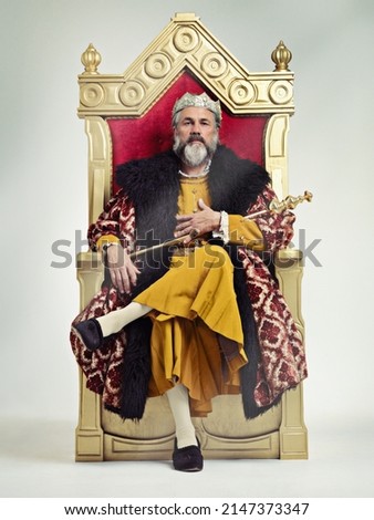 I took the throne peacefully. Studio shot of a richly garbed king sitting on a throne. Royalty-Free Stock Photo #2147373347