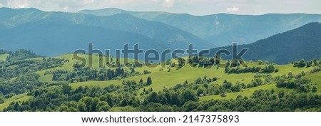 Blue mountains, green valley. Panoramic view of Ukrainian mountains in summer day. Carpathian, Ukraine, Europe. Mountain tourism. Tourism and travel concept. Natural green forest background panorama.  Royalty-Free Stock Photo #2147375893