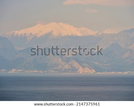 snowy mountain landscape and calm sea