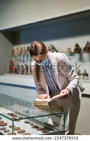 woman with books in museum exhibition