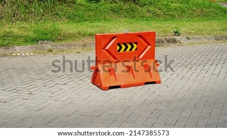 orange colored plastic road barrier on paved road