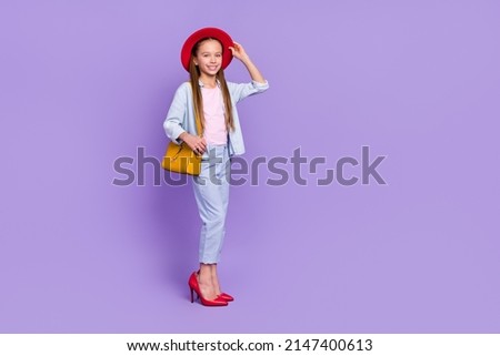 Photo of shiny adorable little school girl wear denim shirt walking mother shoes empty space isolated purple color background