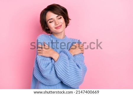 Portrait of adorable girl closed eyes hug shoulders silky clothes isolated on pink color background Royalty-Free Stock Photo #2147400669
