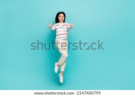 Full size photo of pretty lady jumping up showing thumb-up cheering you up isolated on turquoise color background