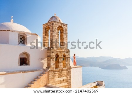 Young girl enjoying breathtaking sunset view from atop of Greek Orthodox church in Plaka village on Milos island Royalty-Free Stock Photo #2147402569