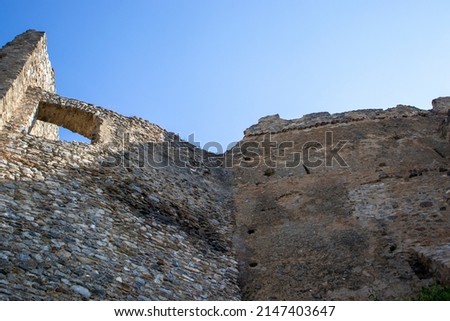 Ruins of the Old Castle on the Background of the Blue Sky. Hill Fortress Ruins, Ancient Building. Photograph of the Ruins of the Old Castle.