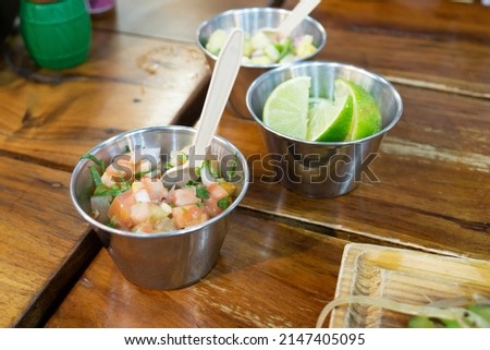Traditional appetizer in a Mexican restaurant. Buckets filled for tortilla filling, lime, tomatoes with onions, pineapple with spices.