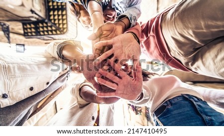 Young happy people stacking hands together outdoor - Community of multiracial international people supporting each other - Help, support and collaboration concept Royalty-Free Stock Photo #2147410495