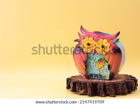 Colorful metallic owl on trunk slice with copy space