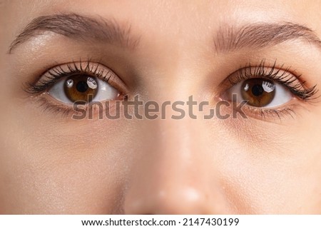 Calm look. Close-up cropped image of beautiful female brown eyes showing different emotions. Youth culture. Natural beauty. Concept of human emotions, facial expression, beauty. Copy space for ad Royalty-Free Stock Photo #2147430199